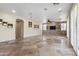 Spacious living room featuring stone accent wall, tile flooring, plantation shutters, and recessed lighting at 8621 W Morten Ave, Glendale, AZ 85305