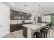 Modern kitchen features dark cabinetry, large island with granite countertop, stainless steel appliances, and pendant lighting at 8735 N 185Th Ave, Waddell, AZ 85355