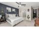 Inviting primary bedroom features a ceiling fan, accent wall, soft carpet, and ensuite bathroom at 8735 N 185Th Ave, Waddell, AZ 85355