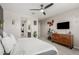 Bright primary bedroom with ceiling fan, TV, and ensuite bathroom with walk-in closet access at 8735 N 185Th Ave, Waddell, AZ 85355
