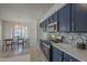 Charming eat-in kitchen area showcases navy cabinets, stainless appliances, tile floors, and bright natural light at 890 N Bogle Ct, Chandler, AZ 85225
