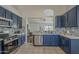 Updated kitchen features navy cabinets, stainless appliances, stylish tile backsplash, and easy access to the living area at 890 N Bogle Ct, Chandler, AZ 85225