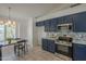 Bright eat-in kitchen shows navy cabinets, stainless appliances, tile flooring, and a door to the outside at 890 N Bogle Ct, Chandler, AZ 85225