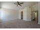 Spacious main bedroom with neutral carpet, ceiling fan, open closet and access to a bathroom at 890 N Bogle Ct, Chandler, AZ 85225