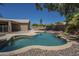 Inviting backyard pool surrounded by palm trees, rocks, and desert landscaping at 890 N Bogle Ct, Chandler, AZ 85225