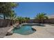 Inviting backyard pool surrounded by palm trees, rocks, and desert landscaping at 890 N Bogle Ct, Chandler, AZ 85225
