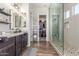 Bright bathroom featuring a dual sink vanity, granite counters and a walk in shower at 9029 S 15Th St, Phoenix, AZ 85042