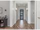 Elegant home foyer featuring wood-look tile flooring, wall sconces, white trim, and glass paneled front door at 9029 S 15Th St, Phoenix, AZ 85042