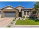 Charming single-story home featuring a stone facade, tile roof, desert landscaping, and a gray two-car garage at 9029 S 15Th St, Phoenix, AZ 85042