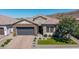 Beautiful single-story home featuring a stone facade, tile roof, desert landscaping, and a gray two-car garage at 9029 S 15Th St, Phoenix, AZ 85042