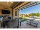 Covered patio area with a dining table, an outdoor television, and a view of the pool at 9029 S 15Th St, Phoenix, AZ 85042