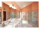 Bathroom featuring double sinks, granite countertops, and glass-enclosed shower at 9235 N 101St St, Scottsdale, AZ 85258