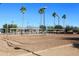 Sandy volleyball court in an outdoor recreational area with palm trees at 9235 N 101St St, Scottsdale, AZ 85258