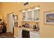 This wet bar has granite countertop, wine refrigerator, glass storage, and sink at 9235 N 101St St, Scottsdale, AZ 85258