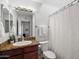 Cozy bathroom features a vanity with granite countertop, toilet and shower with a white curtain at 10115 E Mountain View Rd # 2061, Scottsdale, AZ 85258