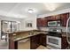 Kitchen features stainless steel appliances, granite countertops, and rich wood cabinetry open to dining area at 10115 E Mountain View Rd # 2061, Scottsdale, AZ 85258