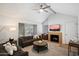 Bright living room with a fireplace, ceiling fan, comfortable seating, and natural light from a large window at 10115 E Mountain View Rd # 2061, Scottsdale, AZ 85258