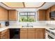 Bright kitchen with a window view, light wood cabinetry, white countertops, and white appliances at 10235 N 31St St # 2, Phoenix, AZ 85028