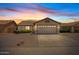 Charming single-story home featuring a two-car garage and desert landscaping against a beautiful sunset sky at 10617 W Ross Ave, Peoria, AZ 85382