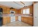 Well-lit kitchen featuring wood cabinets, white appliances, tile flooring, and neutral countertops at 10617 W Ross Ave, Peoria, AZ 85382