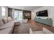 Bright living room features stylish sectional sofa, wood flooring, and sliding glass doors to the backyard at 10964 W Garfield St, Avondale, AZ 85323