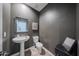 Elegant powder room featuring modern fixtures, stylish mirror, and attractive wall decor at 10964 W Garfield St, Avondale, AZ 85323