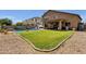 An expansive backyard features a large grassy area, pool, covered patio, and outdoor seating, perfect for relaxing and entertaining at 1130 E Harvest Rd, San Tan Valley, AZ 85140