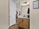 Stylish bathroom featuring a modern vanity, framed mirror, decorative lighting, and open doorway at 1130 E Harvest Rd, San Tan Valley, AZ 85140