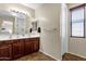 Bathroom featuring a double sink vanity with dark wood cabinets and a large mirror at 1130 E Harvest Rd, San Tan Valley, AZ 85140