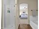 Clean bathroom featuring a glass-enclosed shower and a view into a Primary bedroom at 1130 E Harvest Rd, San Tan Valley, AZ 85140