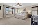 Spacious bedroom showcasing a large bed, neutral decor, and abundant natural light at 1130 E Harvest Rd, San Tan Valley, AZ 85140