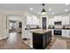 Open kitchen with center island, black cabinets, white perimeter cabinets, and stainless appliances at 1130 E Harvest Rd, San Tan Valley, AZ 85140
