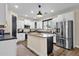 Bright kitchen features stainless appliances, white cabinets, and center island with sleek dark counter at 1130 E Harvest Rd, San Tan Valley, AZ 85140