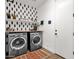 Well-organized laundry room with modern washer and dryer, decorative shelves, and stylish wallpaper at 1130 E Harvest Rd, San Tan Valley, AZ 85140