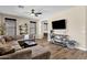 Living room featuring large sectional couch, ceiling fan, and natural light from the windows at 1130 E Harvest Rd, San Tan Valley, AZ 85140