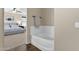 Bright main bedroom with large bed, fan, and a soaking tub in the ensuite bathroom at 1130 E Harvest Rd, San Tan Valley, AZ 85140