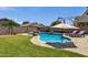A tranquil backyard pool features a rock waterfall, lush lawn, and comfortable lounge chairs, perfect for relaxation and recreation at 1130 E Harvest Rd, San Tan Valley, AZ 85140