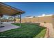 A well-maintained backyard features a covered patio, green grass, and a block wall at 11615 N 77Th Dr, Peoria, AZ 85345