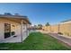 The backyard features a covered patio, a lush lawn, and a sparkling pool, offering a perfect outdoor oasis at 11615 N 77Th Dr, Peoria, AZ 85345