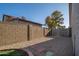 Backyard area featuring hardscape, brick wall, grass, gravel, and a view of neighboring houses at 11615 N 77Th Dr, Peoria, AZ 85345