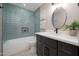 A stylish bathroom boasts teal subway tile, a modern vanity, and decorative artwork at 11615 N 77Th Dr, Peoria, AZ 85345