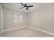 A neutral-toned bedroom features tile floors, a ceiling fan, and a window with horizontal blinds at 11615 N 77Th Dr, Peoria, AZ 85345