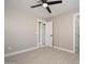 A neutral-toned bedroom features tile floors, a ceiling fan, and a white door at 11615 N 77Th Dr, Peoria, AZ 85345