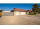 The side exterior showcases a two-car garage, desert rock landscaping, and gated access at 11615 N 77Th Dr, Peoria, AZ 85345