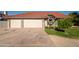 Home with a spacious driveway leading to a two-car garage, complemented by desert landscaping at 11615 N 77Th Dr, Peoria, AZ 85345