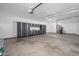 An organized garage features storage cabinets, overhead lighting, and a clean concrete floor at 11615 N 77Th Dr, Peoria, AZ 85345