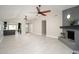 Open-concept living room with a fireplace, tile flooring, and ceiling fans for comfort at 11615 N 77Th Dr, Peoria, AZ 85345