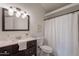 Bright bathroom featuring a vanity with a dark wood cabinet and stone countertop, along with a toilet and shower at 1165 E Ivanhoe St, Chandler, AZ 85225