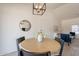 Dining area with a round wood table, seating for four, and contemporary light fixture for cozy meals at 1165 E Ivanhoe St, Chandler, AZ 85225