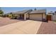 A single-Gathering home with a long driveway leading to an attached two-car garage, and xeriscaped front yard at 1165 E Ivanhoe St, Chandler, AZ 85225